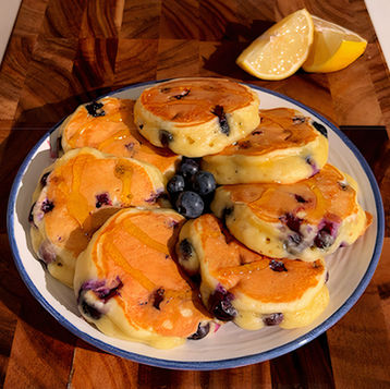 Un piatto di pancake mirtilli e limone, con miele e mirtilli freschi