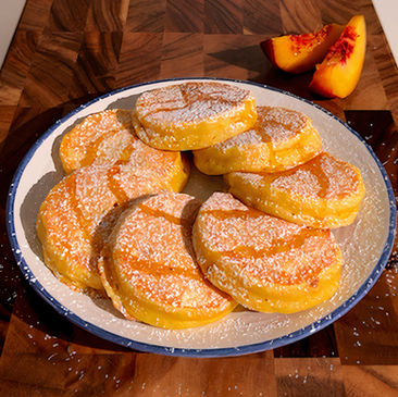 Un piatto di pancake alla frutta, con pesche e miele