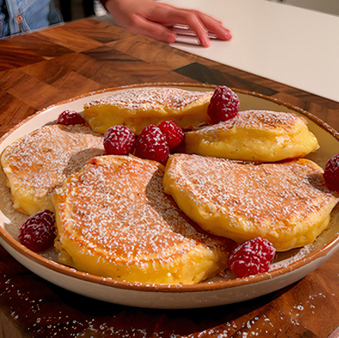 Un piatto di pancake al cioccolato bianco e lamponi