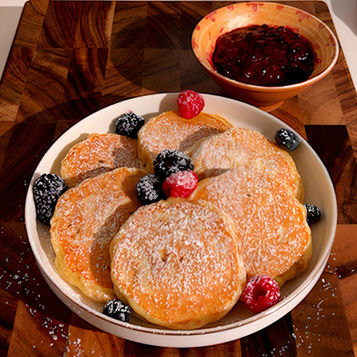 Un piatto di pancake al gusto cheesecake, con frutti di bosco