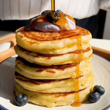 Una pila di pancake senza burro, con yogurt, mirtilli freschi e sciroppo d'acero