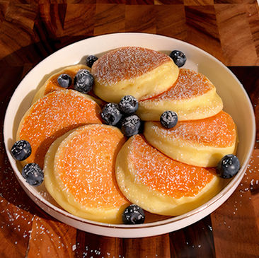 Un piatto di pancake magici al limone senza farina, con ricotta e mirtilli