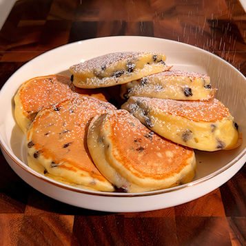 Soffici e alti pancake alla ricotta e cioccolato, con zucchero a velo