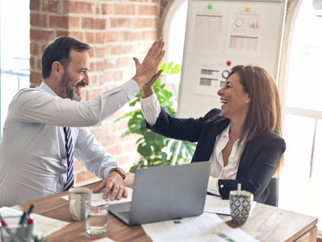 Two people high-fiving over work