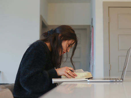 A young woman with black hair studying at home