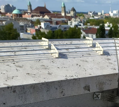 eine Naturstein-Attika wird mit OTES Keramik gegen Krähen geschützt