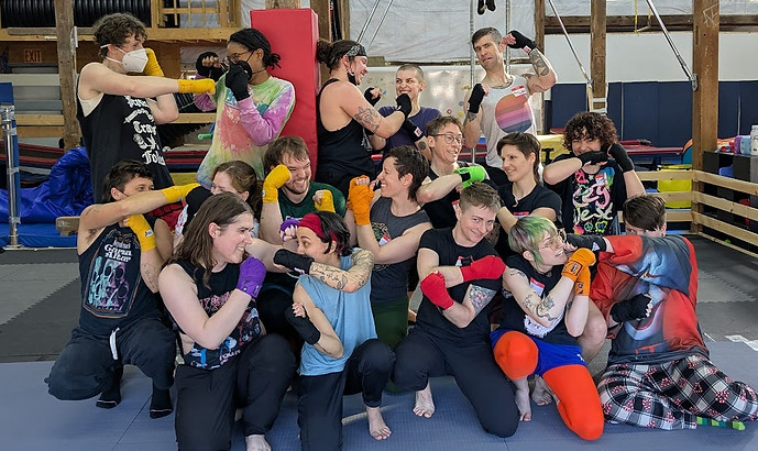 The intro muay thai class poses for a photo with their punches ready
