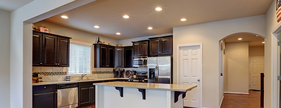 Modern kitchen with dark cabinetry, island seating, and recessed lighting – full kitchen renovation