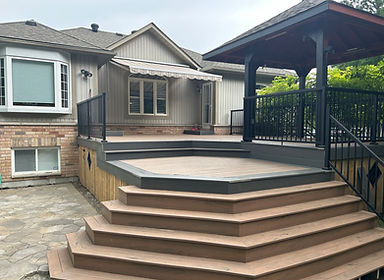 Modern composite deck with black aluminum railings and wide steps – custom outdoor build