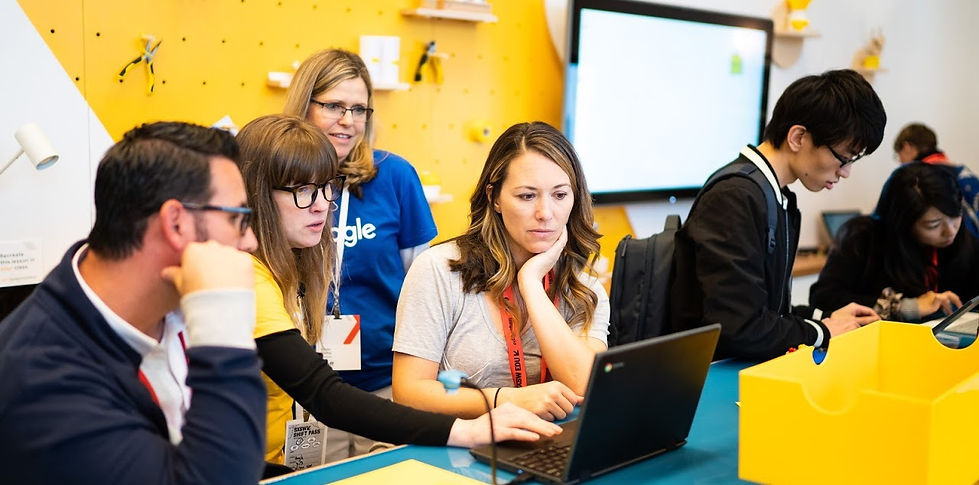 Katie at SXSW surrounded by 3 other people demoing something on a computer.