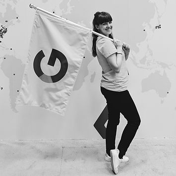 Katie standing holding a google flag over her shoulder as if she is still in marching band like in high school.