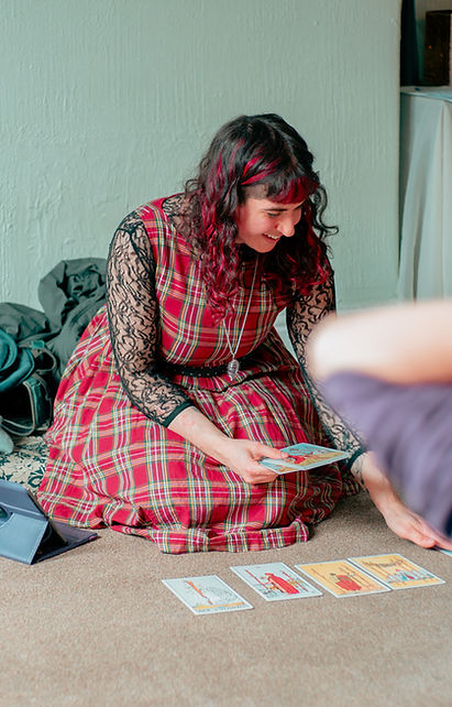 Jess smiling while holding tarot cards for teaching