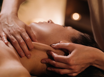 A cosmetologist girl does a facial and neck massage to a girl in the office for skin elast