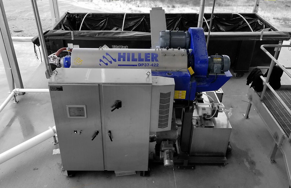 Blue dewatering centrifuge with stainless steel components, situated outdoors.