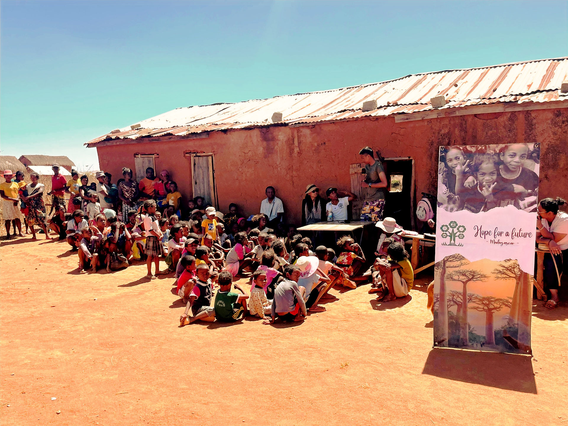 Gathering at the old school building for school supplies distribution