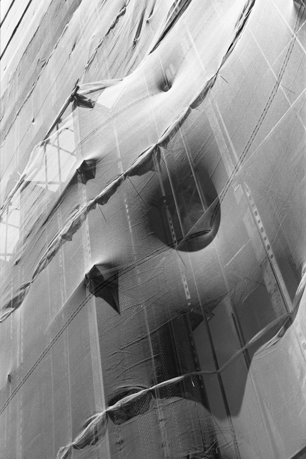 scaffolding at building under renovation with white net and shadows