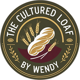Logo for The Cultured Loaf by Wendy showing a rustic sourdough loaf surrounded by wheat, with text in a circular badge