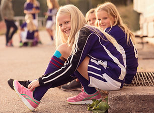 Portrait of Happy Girls Tying Shoes