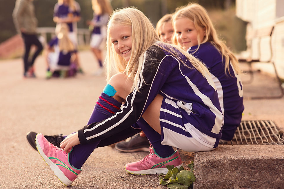 Portrait of Happy Girls Tying Shoes