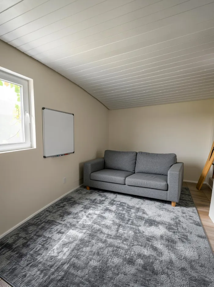 Zonas funcionales del estudio casero visualizadas con ArchiVinci, que muestran una zona de trabajo concentrado, un rincón de música con guitarras y una zona de asientos informal para una man cave creativa.