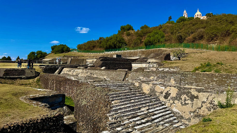 Die archäologische Stätte der Pyramide mit der Kirche im Hintergrund.