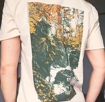 Back view of a t-shirt with a print from The Hermitage on it -autumn leaves surround a folly above a crashing waterfall