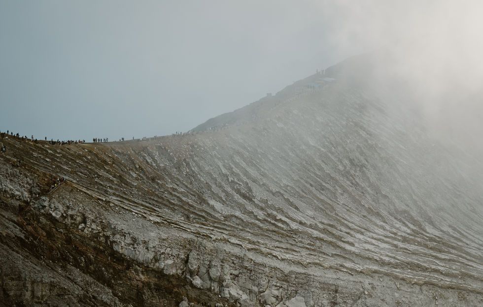 Après une descente au creux du cratère du Kawah Ijen pour y observer les mythiques flammes bleues, on regagne la crête sous les vapeurs de soufre pour le lever du soleil