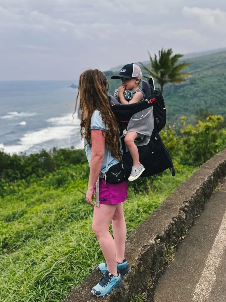 Adrianna hikes Polulu Valley with her son in a carrier on her back, one of the best family hikes on the Big Island.
