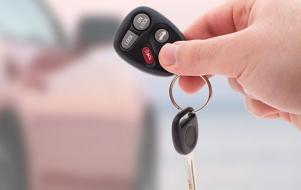 A hand holding a car remote key fob and physical key, symbolizing The Lock Geek's specialized services for car key cutting and remote programming in Cincinnati.