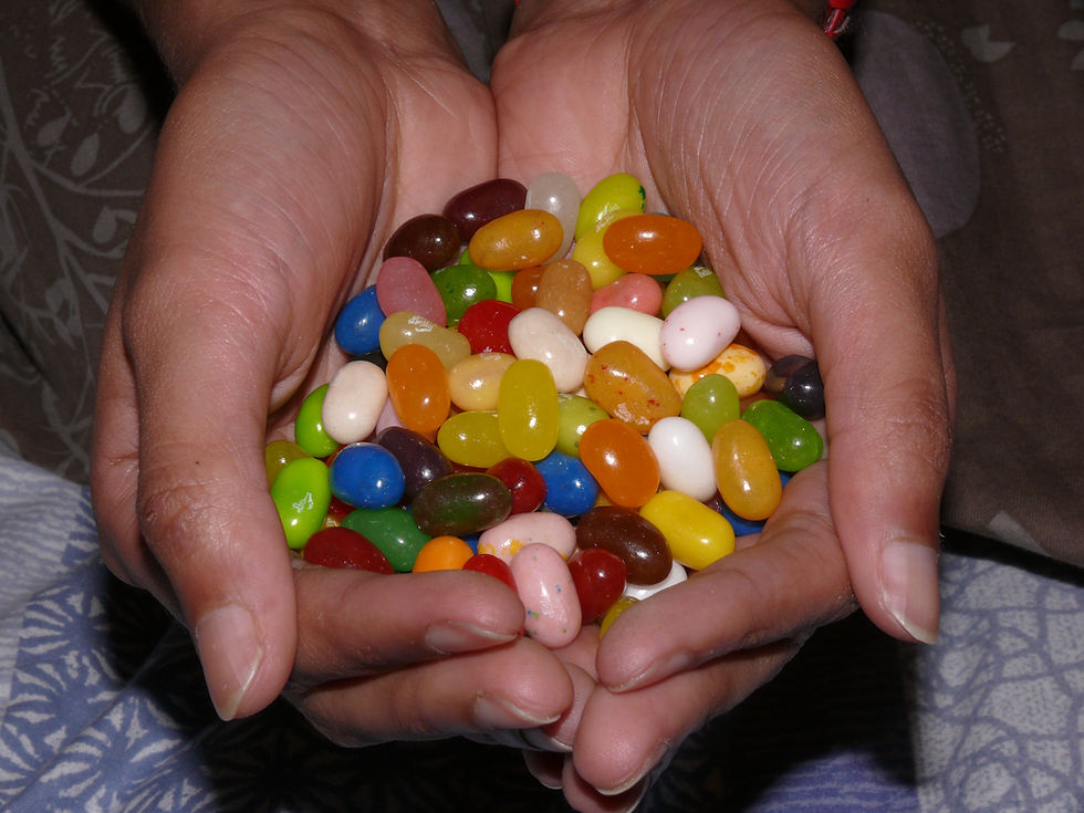 A heap of colourful jellybeans cupped in a pair of hands