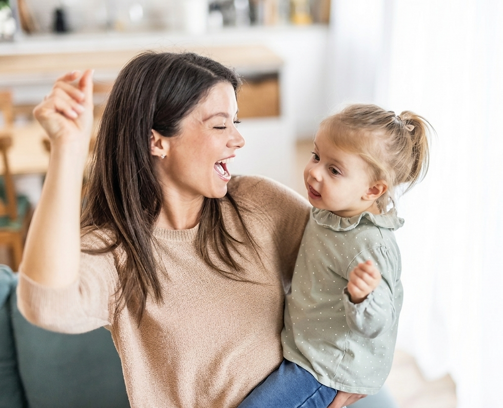 A happy mother holding her toddler daughter in her arms, dancing and singing together in a brightly lit living room.