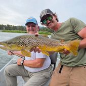 Western River Anglers anglers holding a large trout during a guided fishing trip.