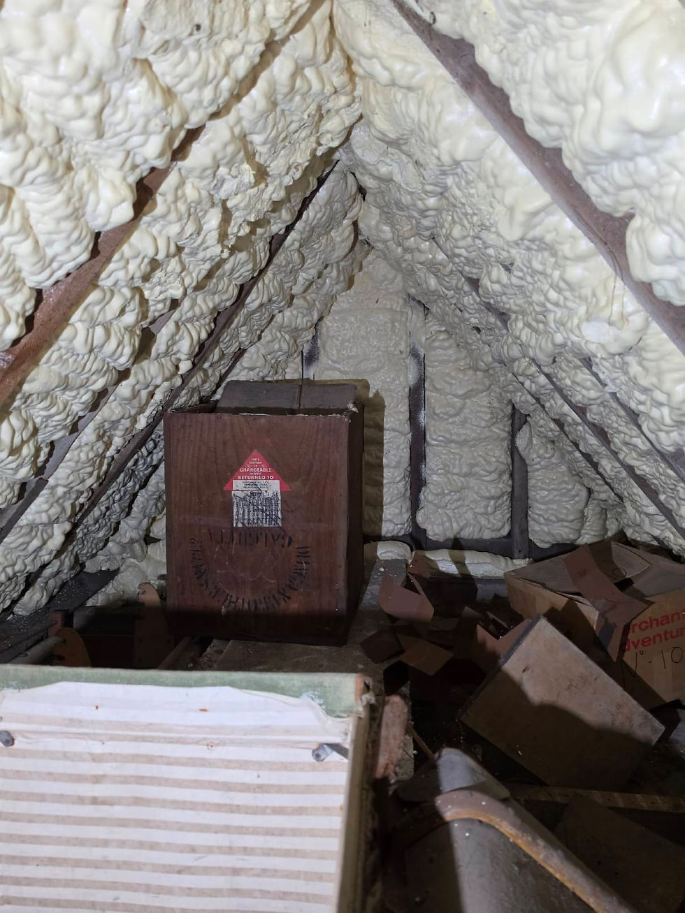 Spray foam insulation in roof space of older property showing restricted ventilation and potential inspection issues for surveyors