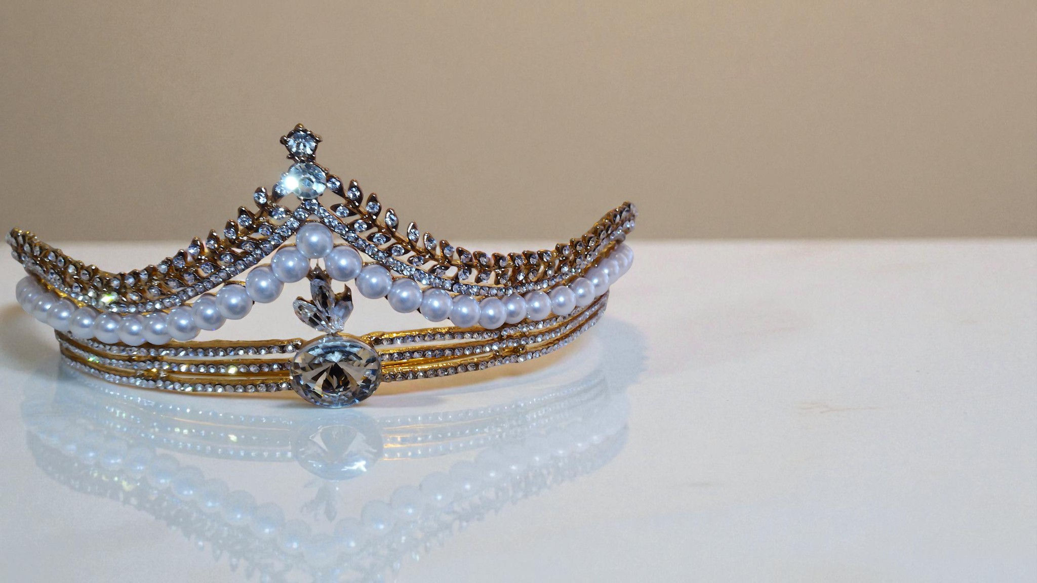 Introducing The Lisa Pearl Beaded Tiara, a timeless display of elegance. This rhinestone and pearl double-layered tiara spark
