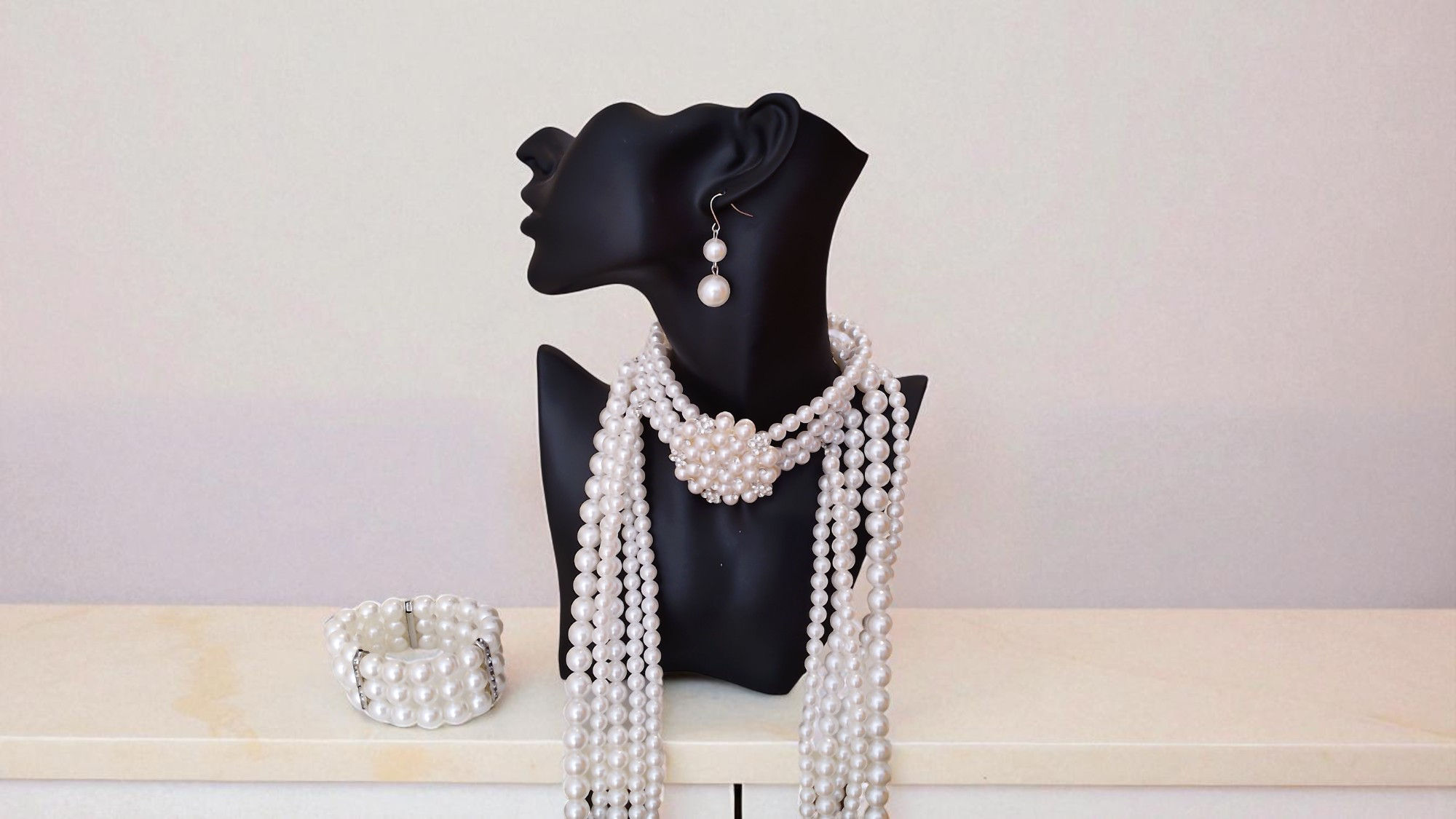 The Ashanti Pearls is dazzling. A rhinestone encrusted broach choker pearl necklace with matching bracelet and earrings.