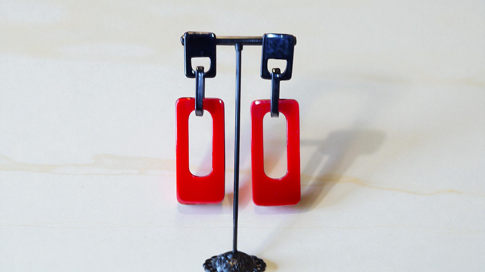 Thumbnail: Discover The Charmaine Earrings, featuring red drop and dangle earrings on a striking black base.