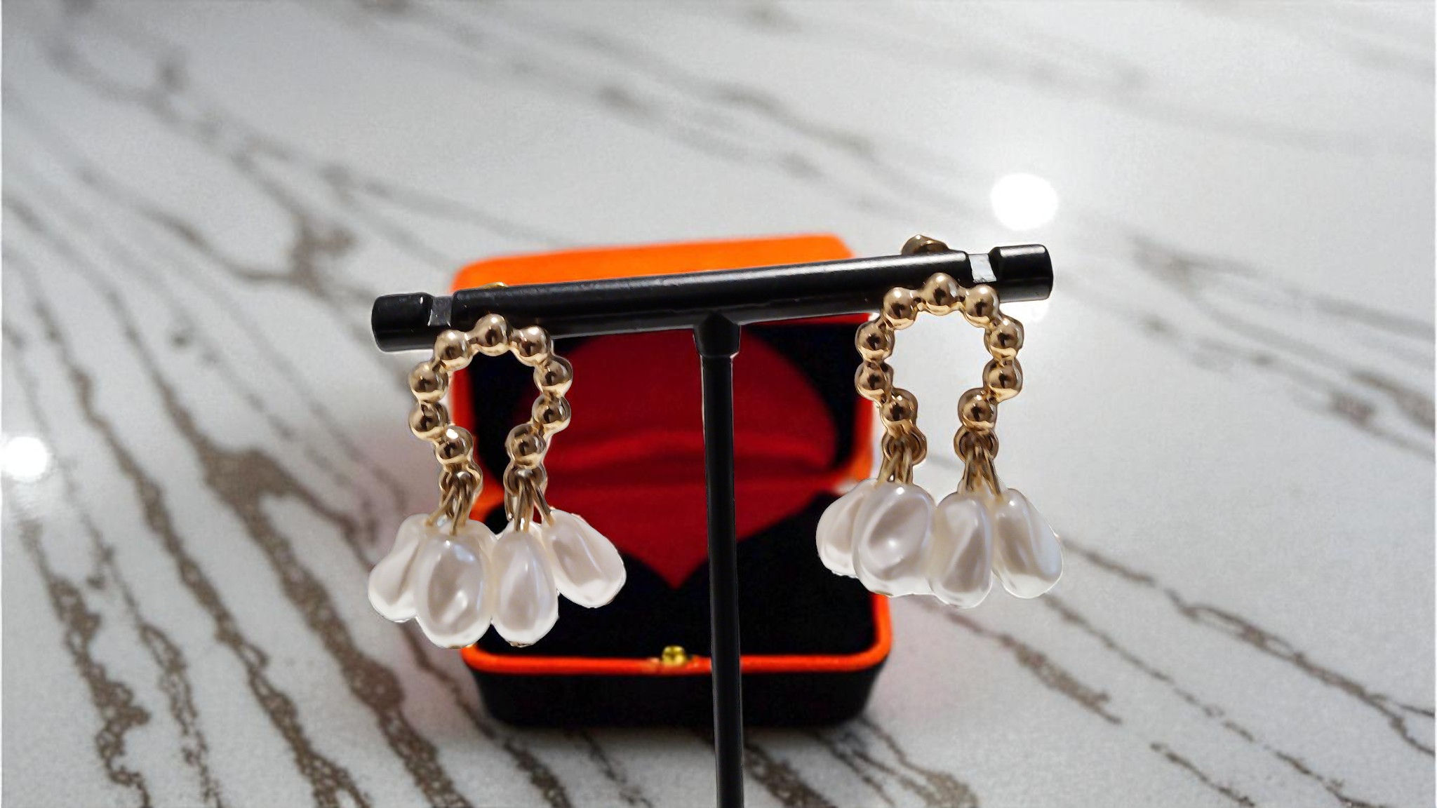 Discover The Floral Bud Earrings at With Love . These gold-toned hoops with pearl tips are perfect for any special occasion.
