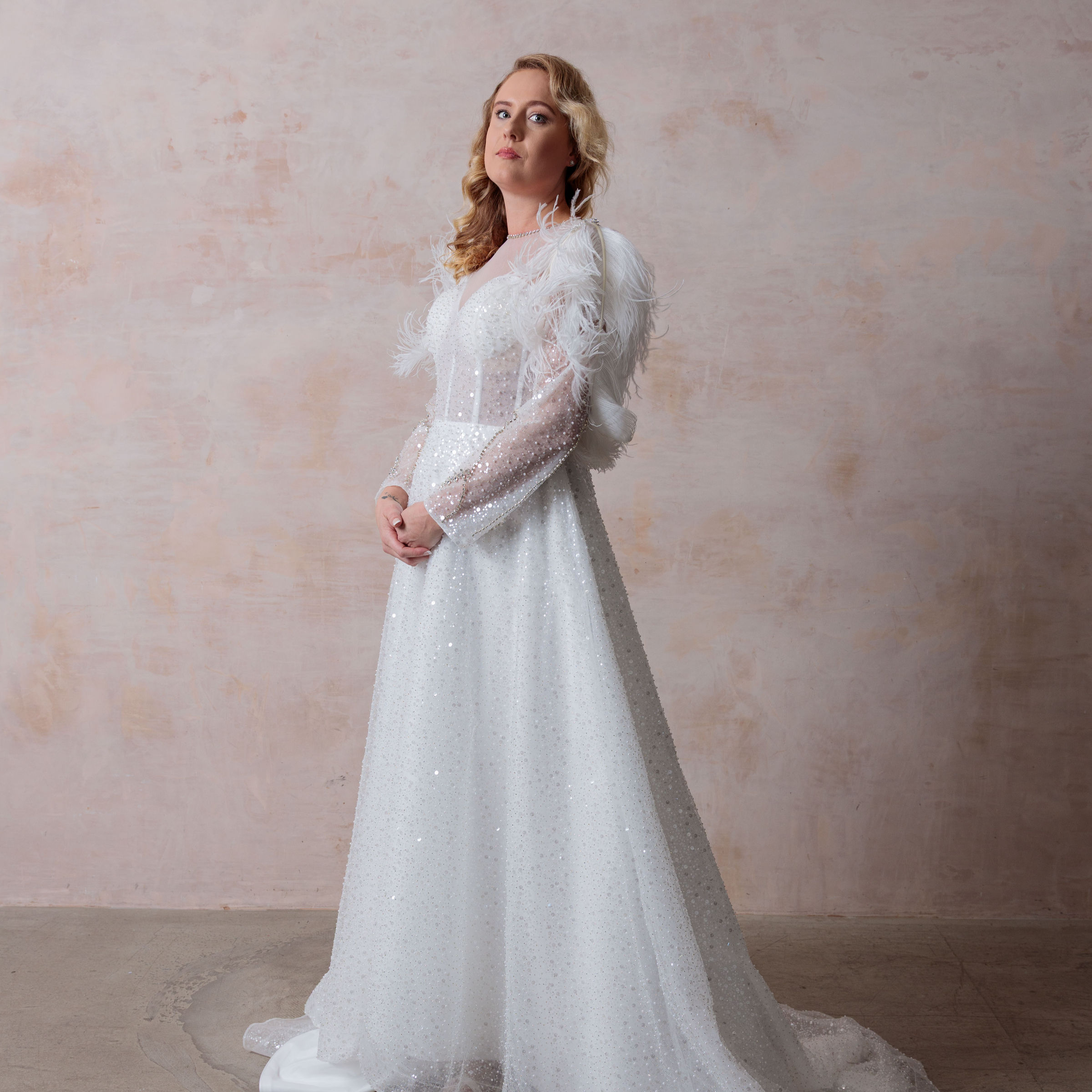 The Stephanie gown from the Joan of London Collection in stunning white, featuring ostrich feathers and hand-sewn beading. BW