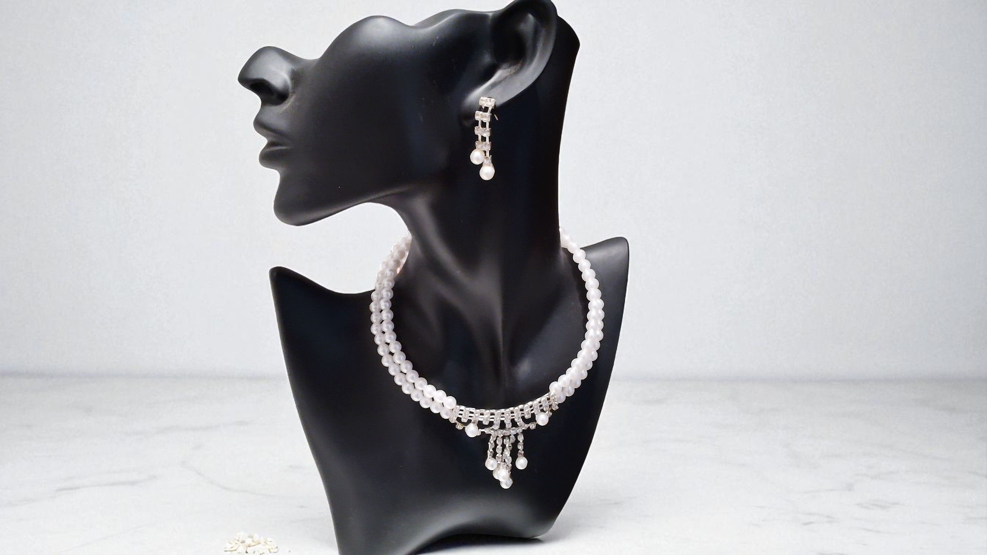 The Alisha Pearls— a pearl choker with a rhinestone centerpiece, dangling rhinestones, and pearl tips. The set includes match