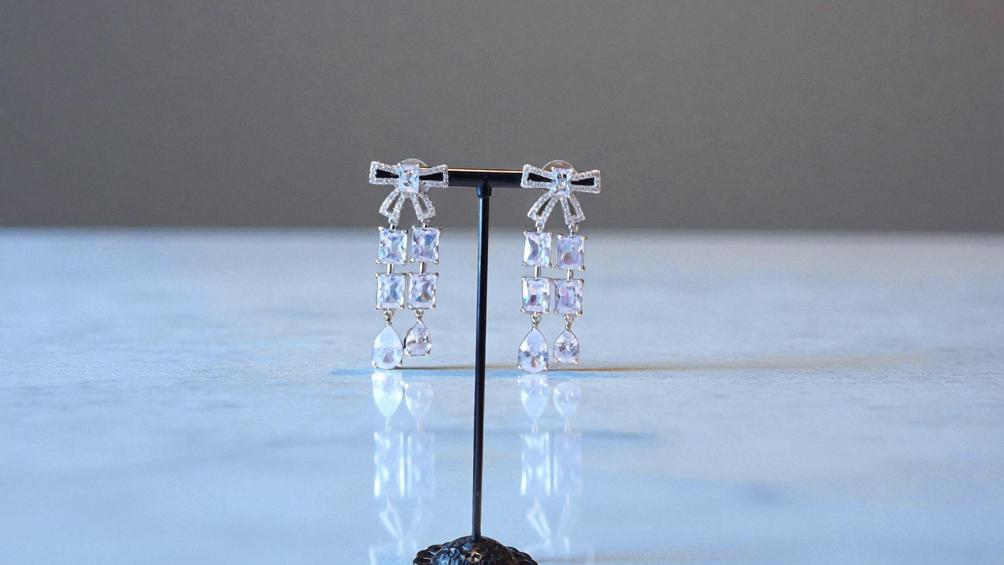 Discover The Latavia Earrings for those who cherish sophistication. Adorned with a rhinestone bow and square rhinestones in a