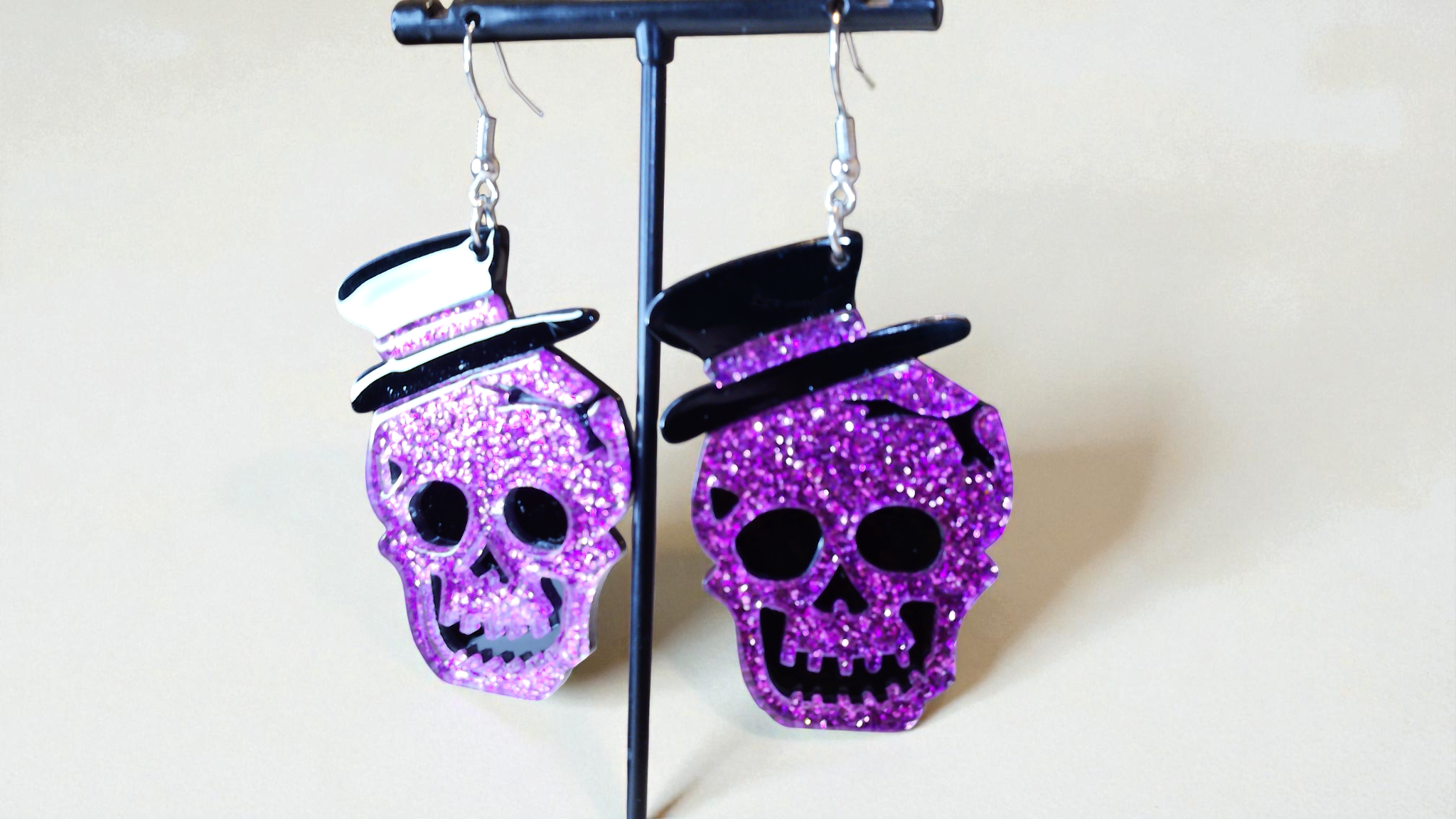 Discover The Skull Earrings—purple skull-shaped earrings with purple rhinestones and black accents. Perfect for edgy elegance