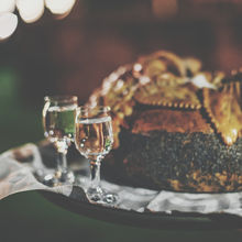 Bochen chleba na tacy z kieliszkami z wódką i wodą, przygotowany do uroczystego podania.