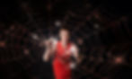 woman in red dress touching a shiny spider web