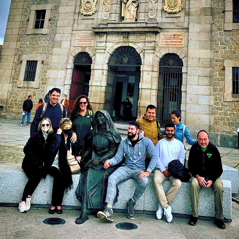 Group photo posing in front of building, with sculpture and Majed Luxury Tours.