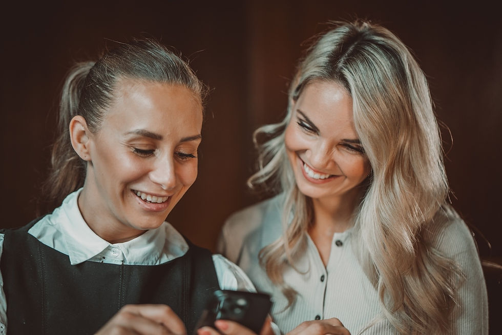 to jenter som er begeistret over noe på mobilen