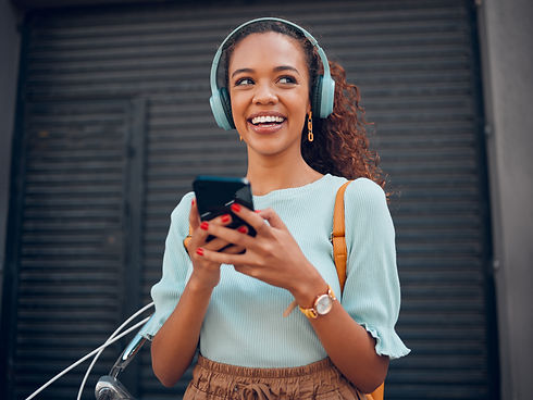 Black woman, smile and phone for social media in the city with headphones in joy for 5G co