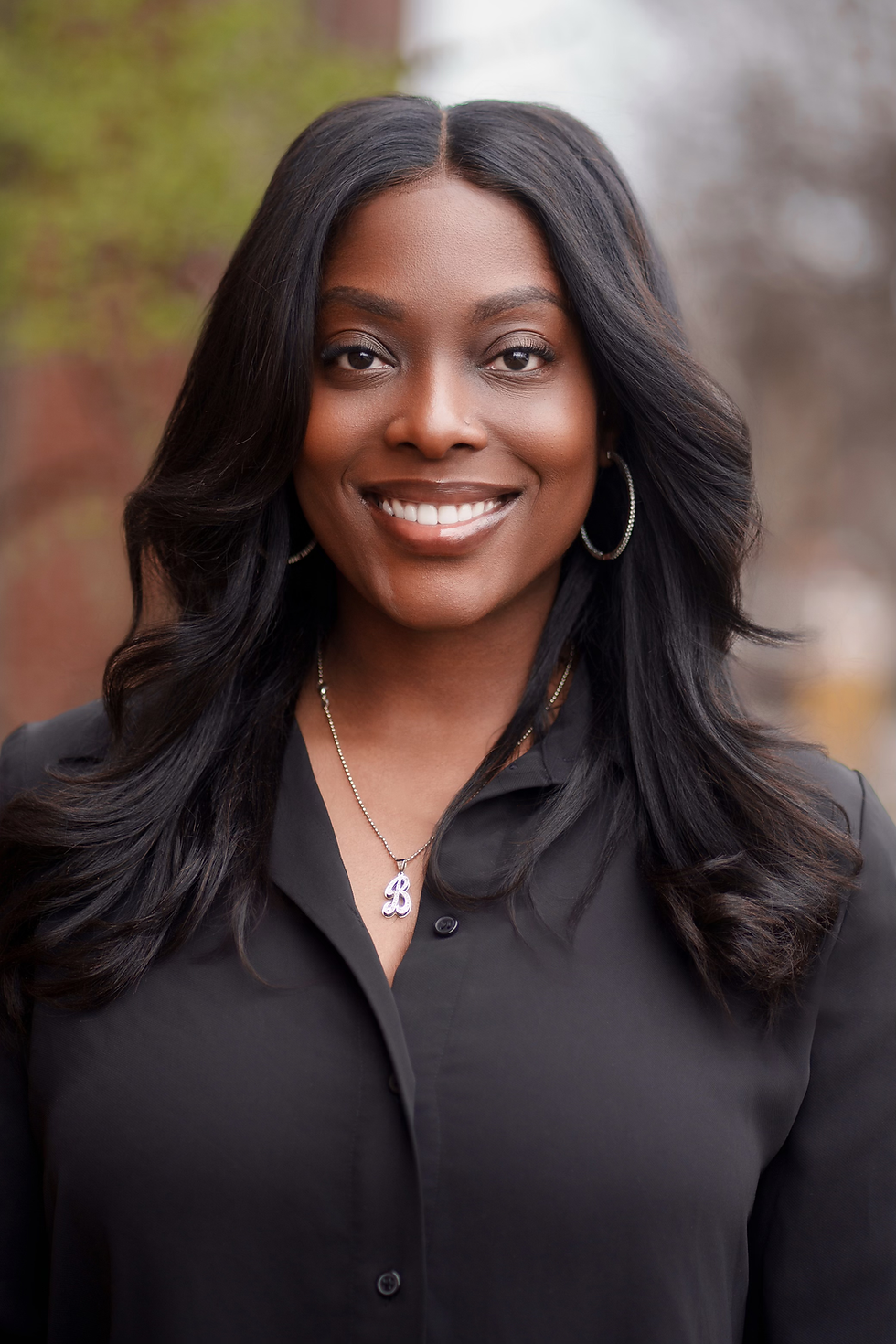 Smiling woman with long black hair, affiliated with Unity Queen Steppers Inc.