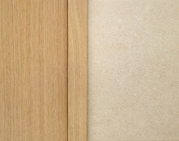 Detalle de contraste de materiales: madera natural y revestimiento de pared texturizado en tonos neutros.