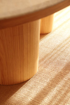 Detalle pata mesa madera y alfombra de yute.