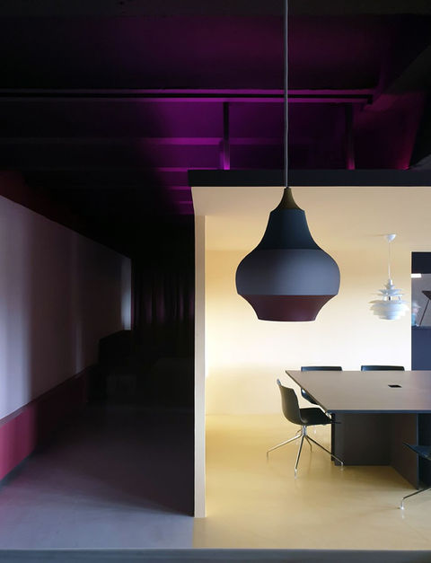 Estudio de diseño creativo para 'Music Has No Limits'. Un ambiente envolvente y sofisticado con una paleta cromática audaz: la profundidad de los tonos oscuros se ilumina con sutiles acentos lilas y puntos vibrantes de amarillo pastel. Un diseño de interiores que inspira creatividad y arte escénico.